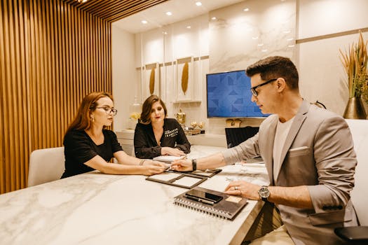Professionals discussing documents at a table in a contemporary office.