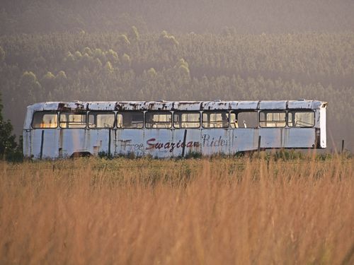 Free An old bus parked in the Malkerns grassland during sunset, offering a rustic travel vibe. Stock Photo