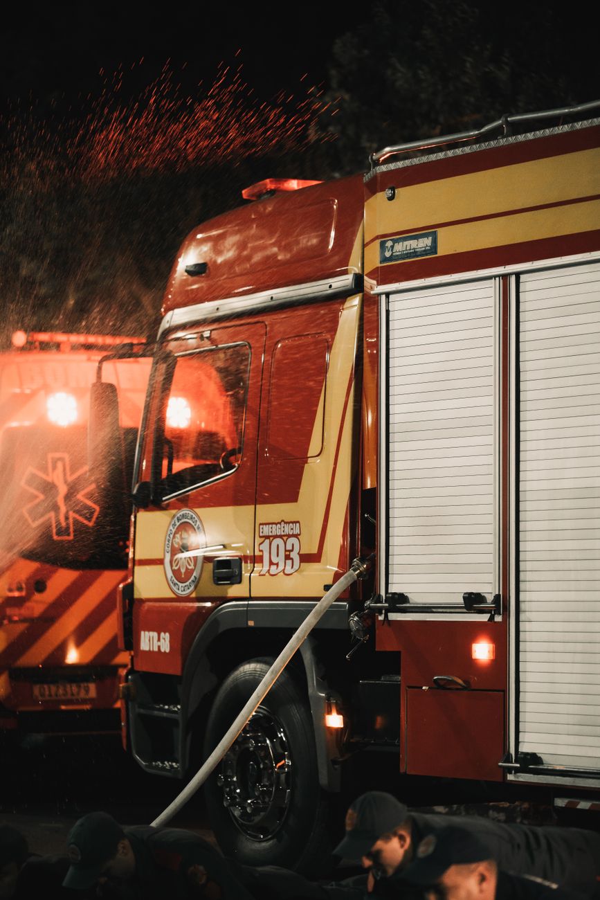 Brandweerlieden reageren op een noodsituatie 's nachts met brandweerwagens en apparatuur in actie.