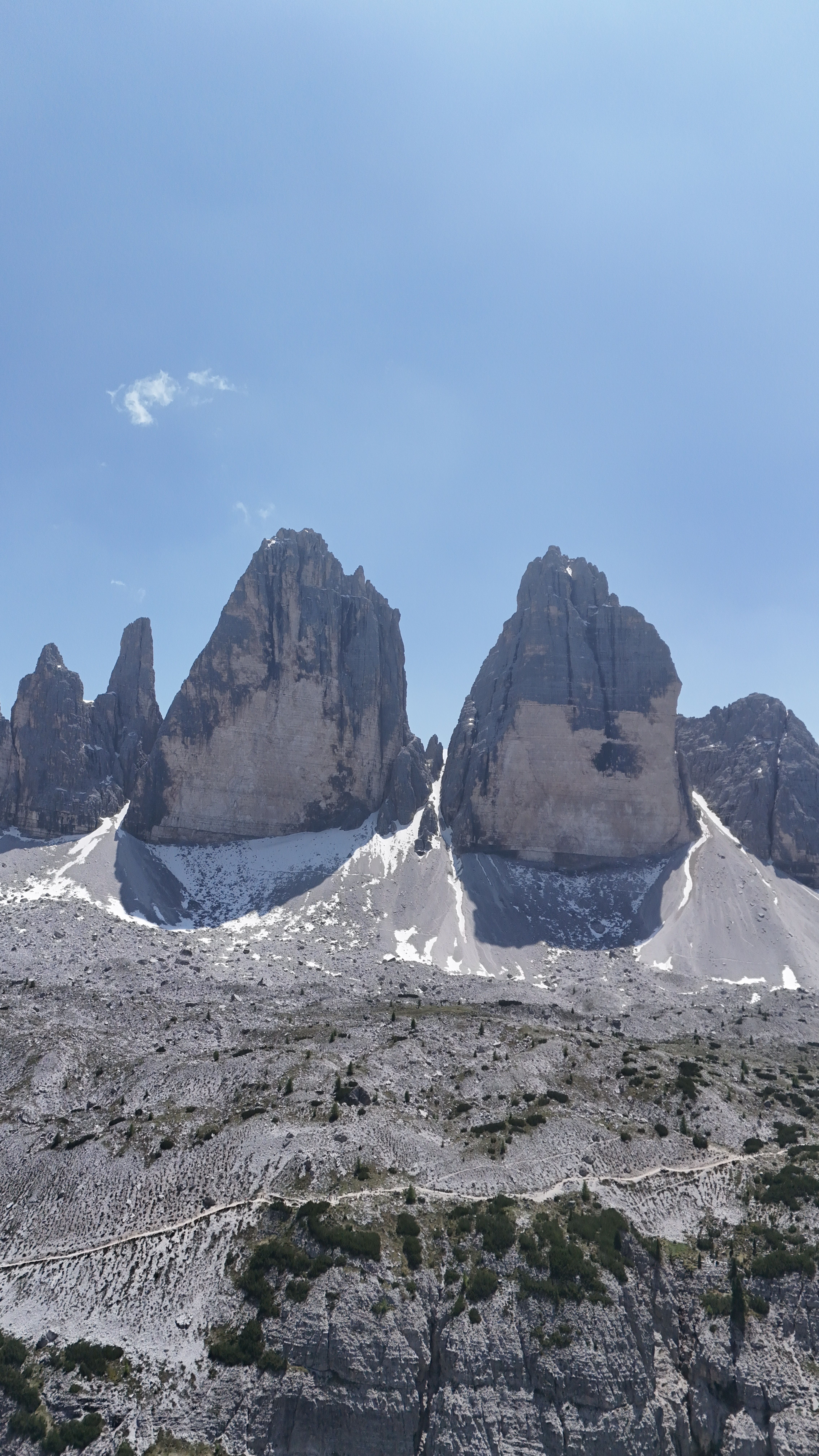 Experience the breathtaking beauty of Tre Cime di Lavaredo's iconic peaks on a clear summer day.