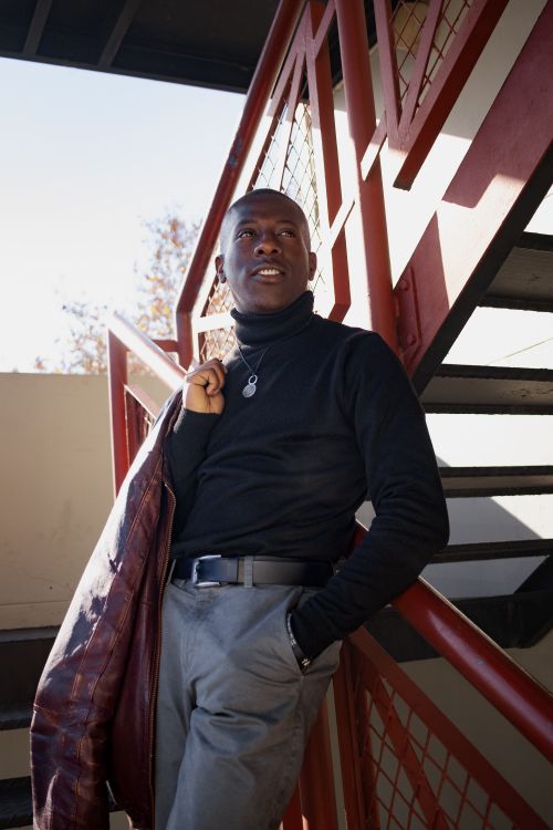 Free Stylish man in turtleneck and jacket posing on staircase outdoors. Stock Photo