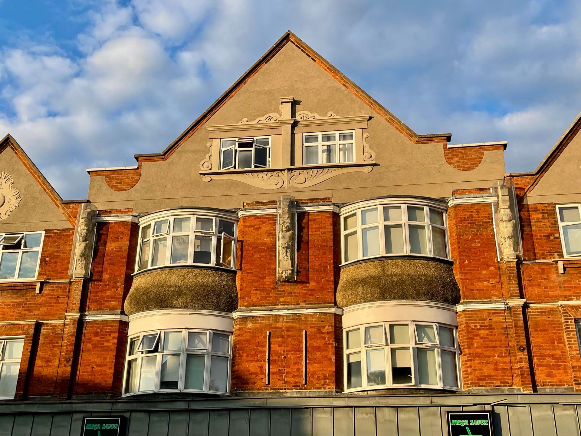 Red brick building facade with stone detailing and bay windows