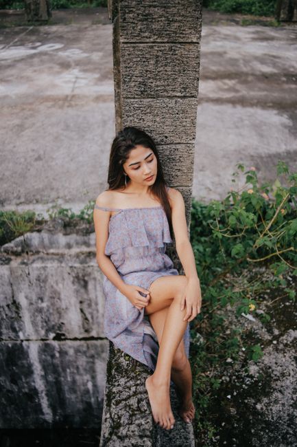 Serene portrait of a young woman in a casual dress outdoors in the Philippines.