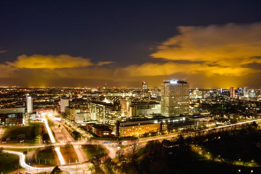 A vibrant night view of the illuminated cityscape of Rotterdam, Netherlands, showcasing modern architecture.