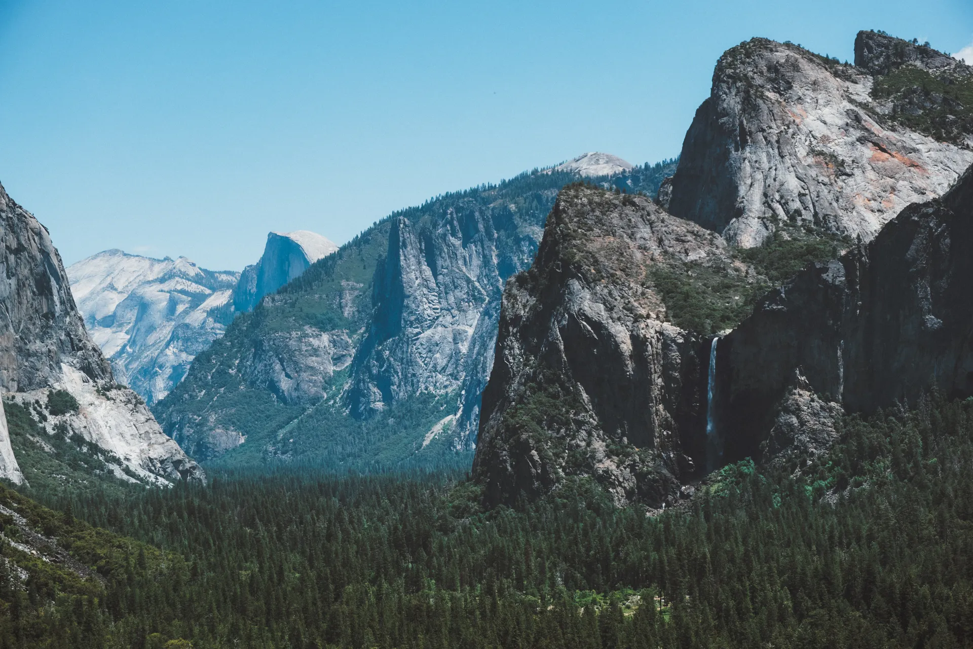 View of Yosemite Valley with a waterfall and granite cliffs in California. View of Yosemite Valley with a waterfall and granite cliffs in California.