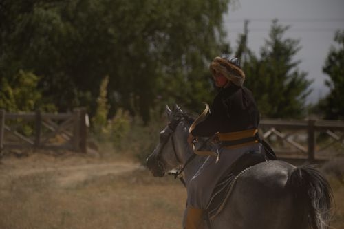 Free A person in traditional attire riding a horse in a rural outdoor setting. Stock Photo