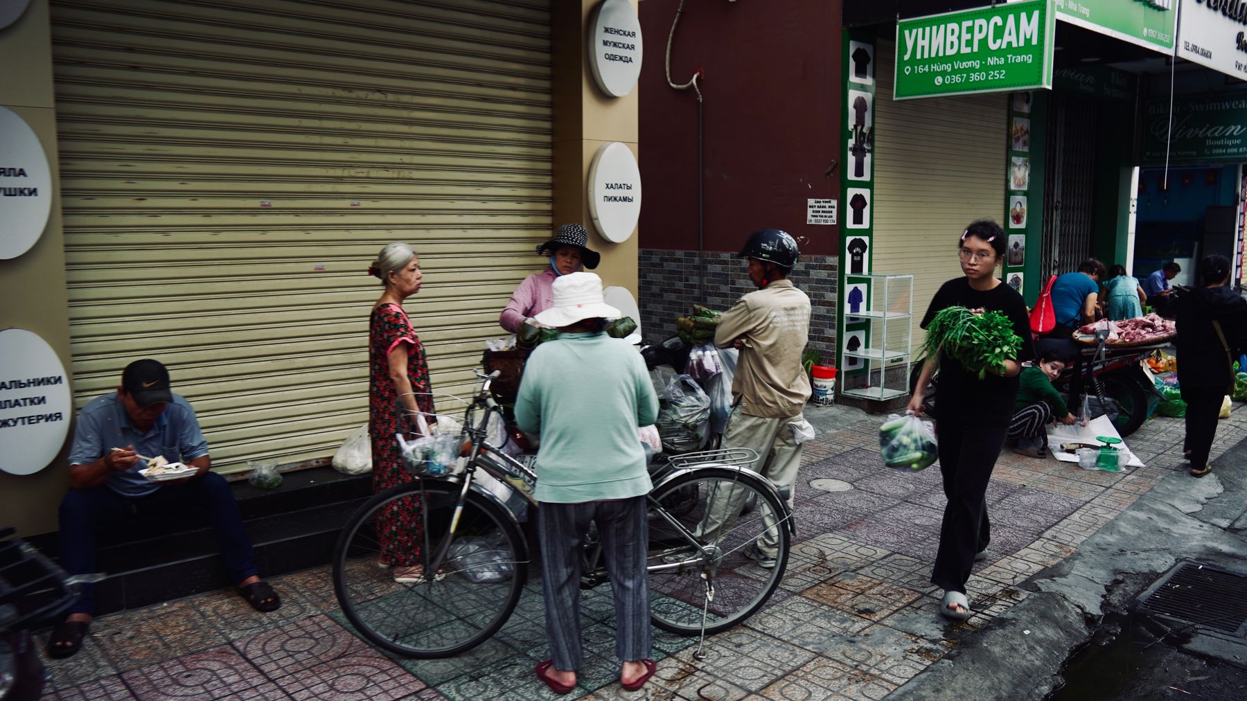 Mercado de rua vibrante em Nha Trang, Vietname, com pessoas e produtos frescos.