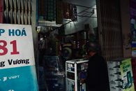 A local convenience store in Vietnam with a customer browsing products.