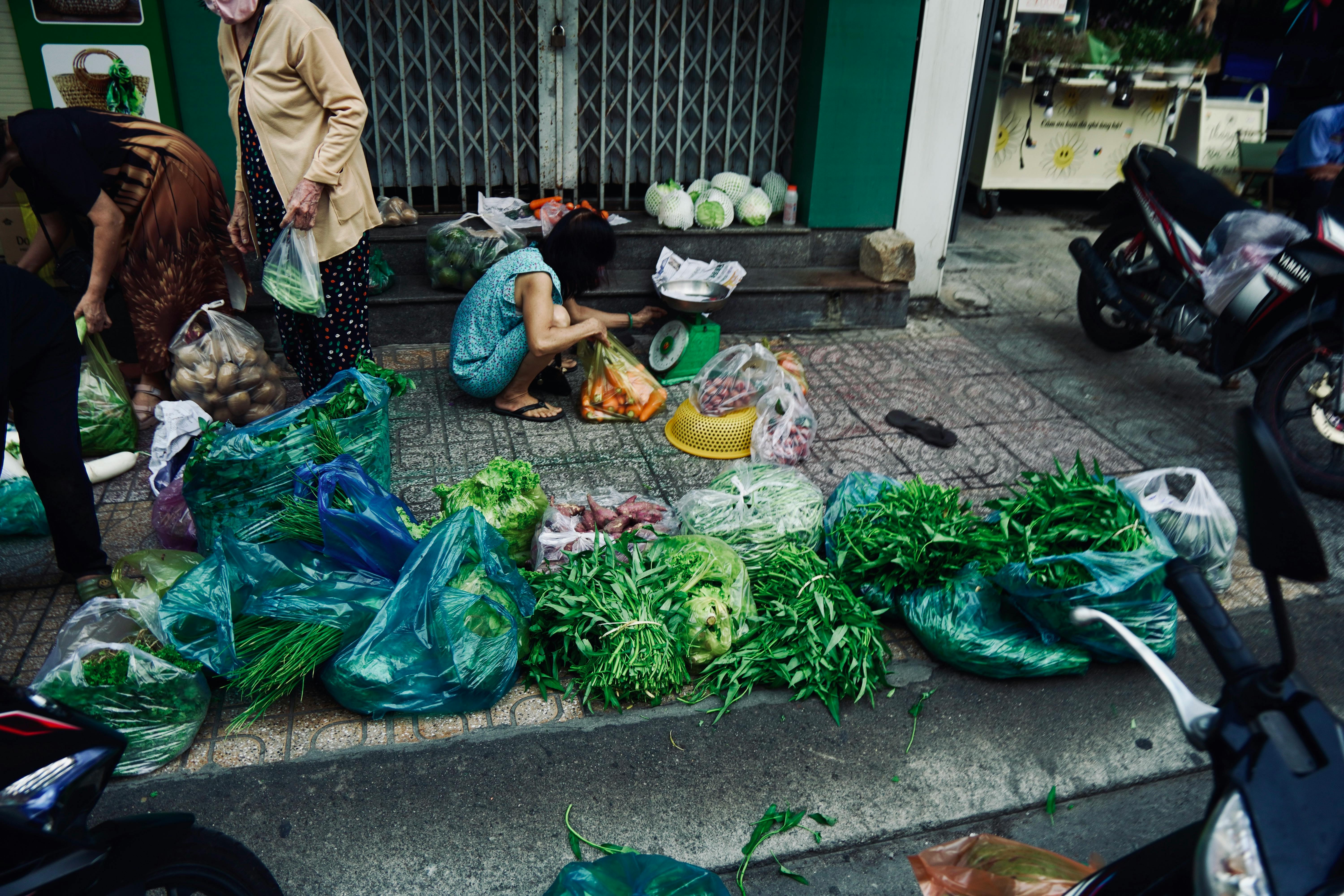 A bustling street market scene showcasing fresh vegetables and local vendors engaged in lively trade.