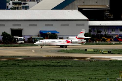 Free A private jet positioned on an airport runway near hangars. Stock Photo