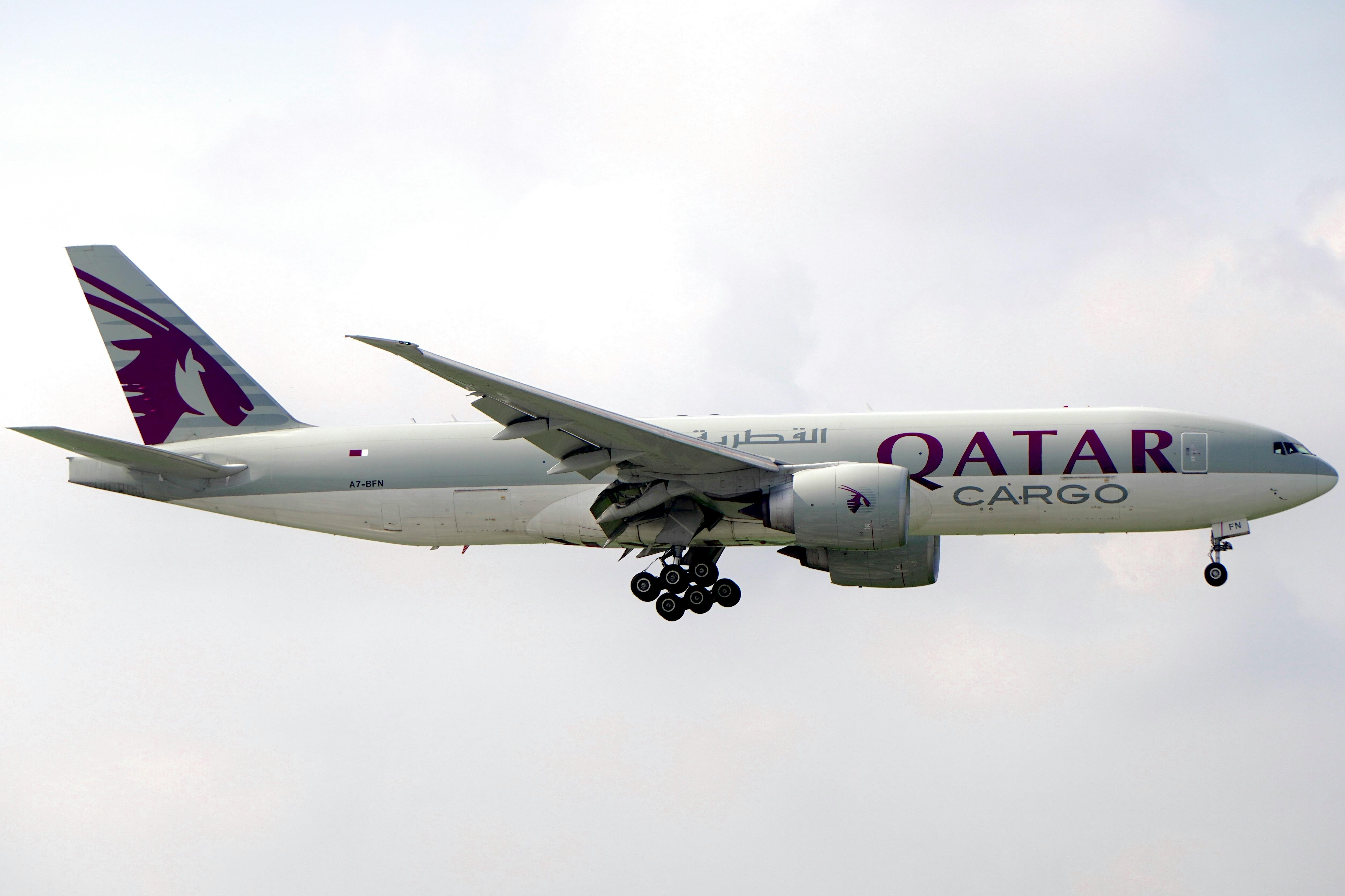 Qatar Cargo airplane captured flying against a cloudy backdrop, showcasing aviation in action.