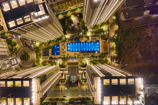 令人惊叹的航拍照片捕捉了印度尼西亚万丹夜间中央游泳池周围明亮的现代建筑