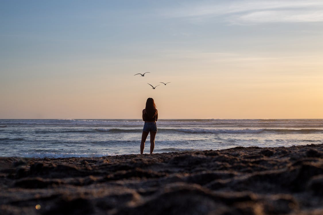 Free Woman Gazing At The Ocean View Stock Photo