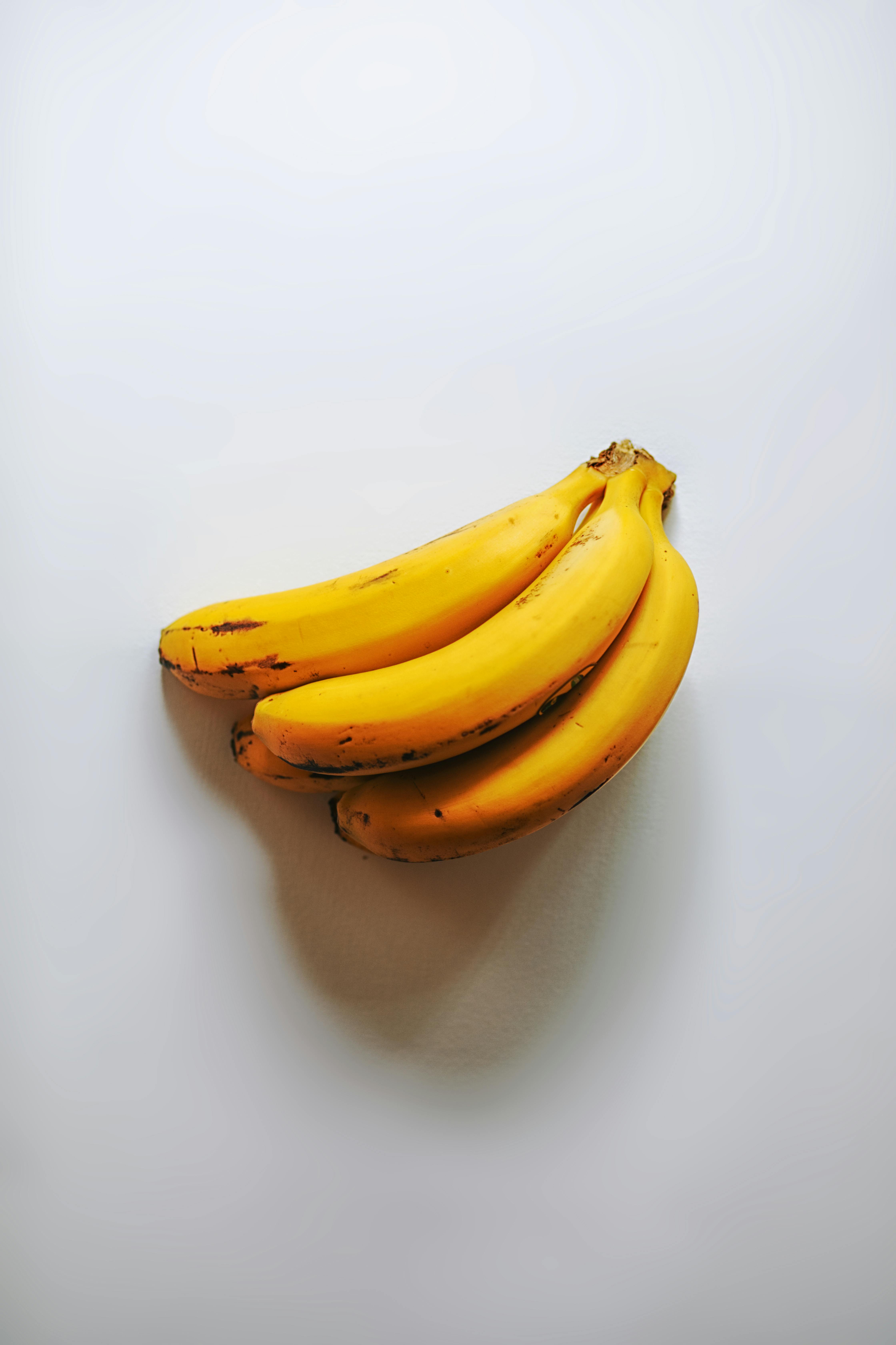 grátis Um cacho de bananas maduras sobre um fundo branco. Perfeito para um design minimalista de comida. Foto profissional