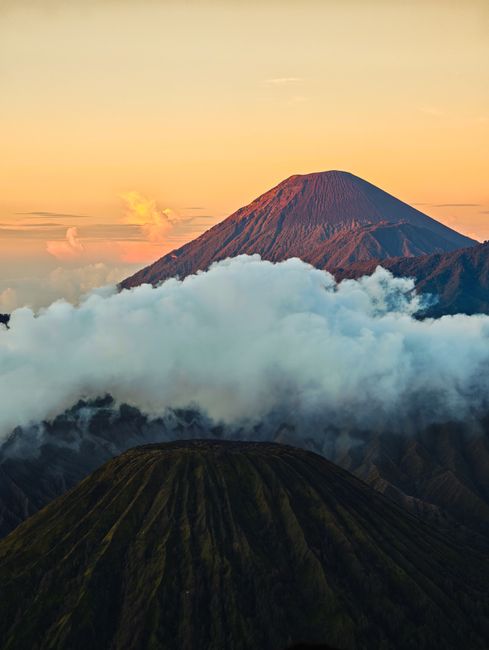 Fotomural Impresionante vista del Monte Bromo al amanecer, rodeado de nubes brumosas en Java Oriental, Indonesia.