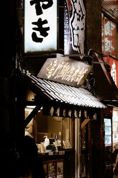 Illuminated storefronts and glowing signs in Shinjuku at night, capturing urban Tokyo's vibrant atmosphere.