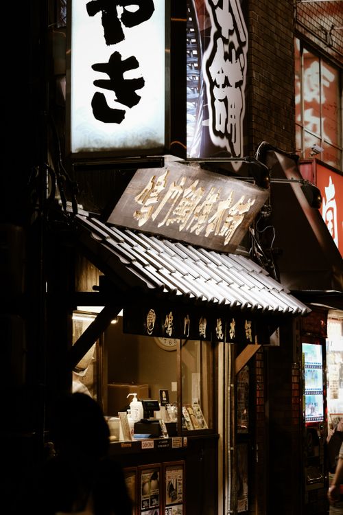 Free Illuminated storefronts and glowing signs in Shinjuku at night, capturing urban Tokyo's vibrant atmosphere. Stock Photo