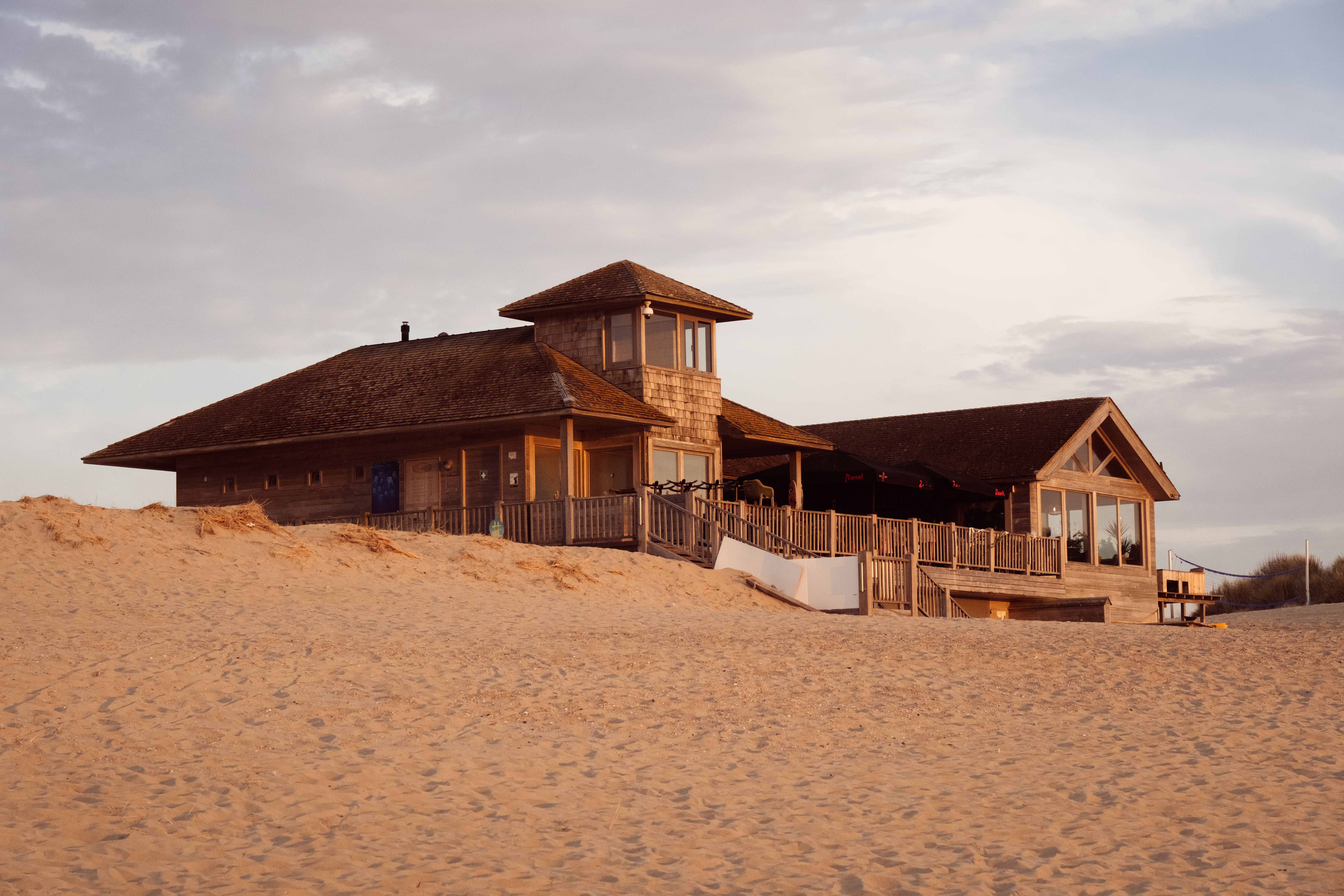 Wooden beach house amidst sand dunes in Middelkerke, Belgium during a serene day.