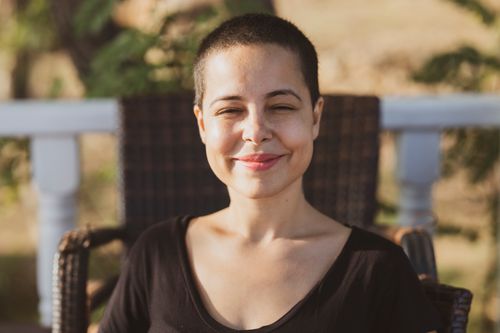 Free A young woman with a buzz cut enjoys the summer sun, her smile radiating happiness and relaxation. Stock Photo