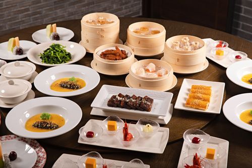 Free A vibrant spread of Chinese dim sum featuring steamed dumplings and sweet desserts. Stock Photo