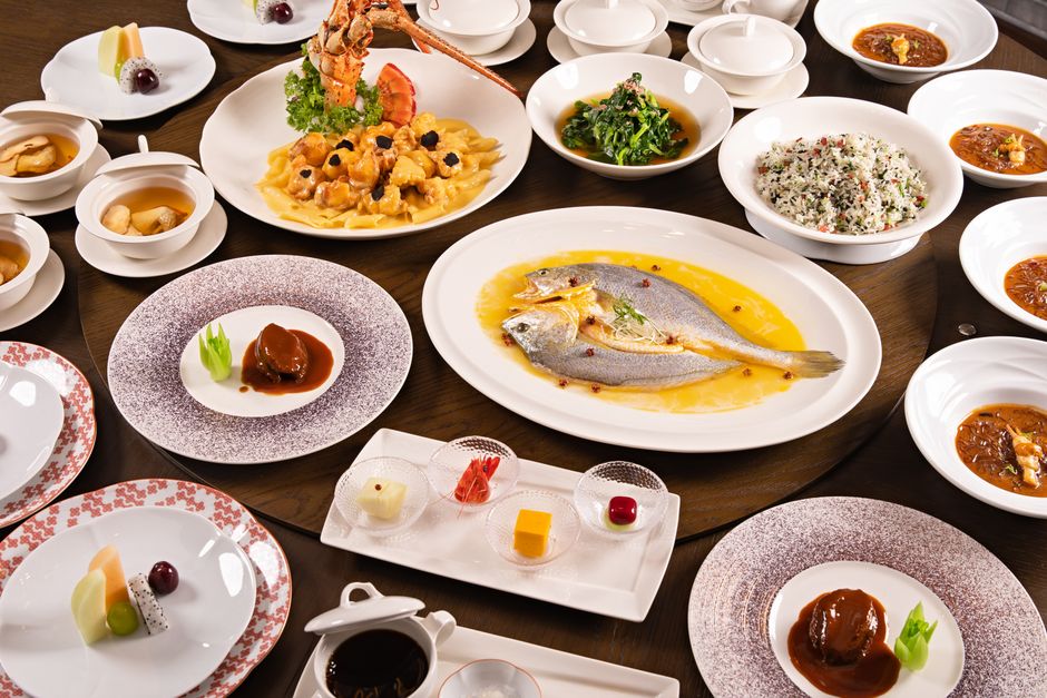 Luxurious fine dining setup with seafood, meat, and dessert dishes elegantly presented on a circular table.