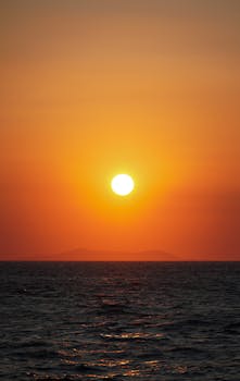 Experience the serene beauty of a sunset over the ocean with vibrant colors blending into the horizon.