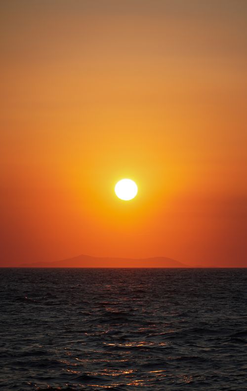 Free Experience the serene beauty of a sunset over the ocean with vibrant colors blending into the horizon. Stock Photo