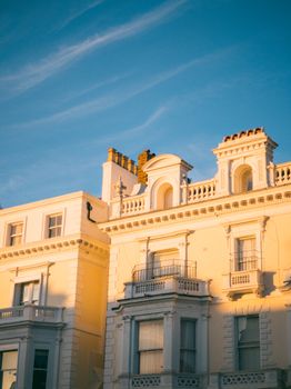 Victorian building exterior with ornate details illuminated by warm sunset light, capturing classic elegance.