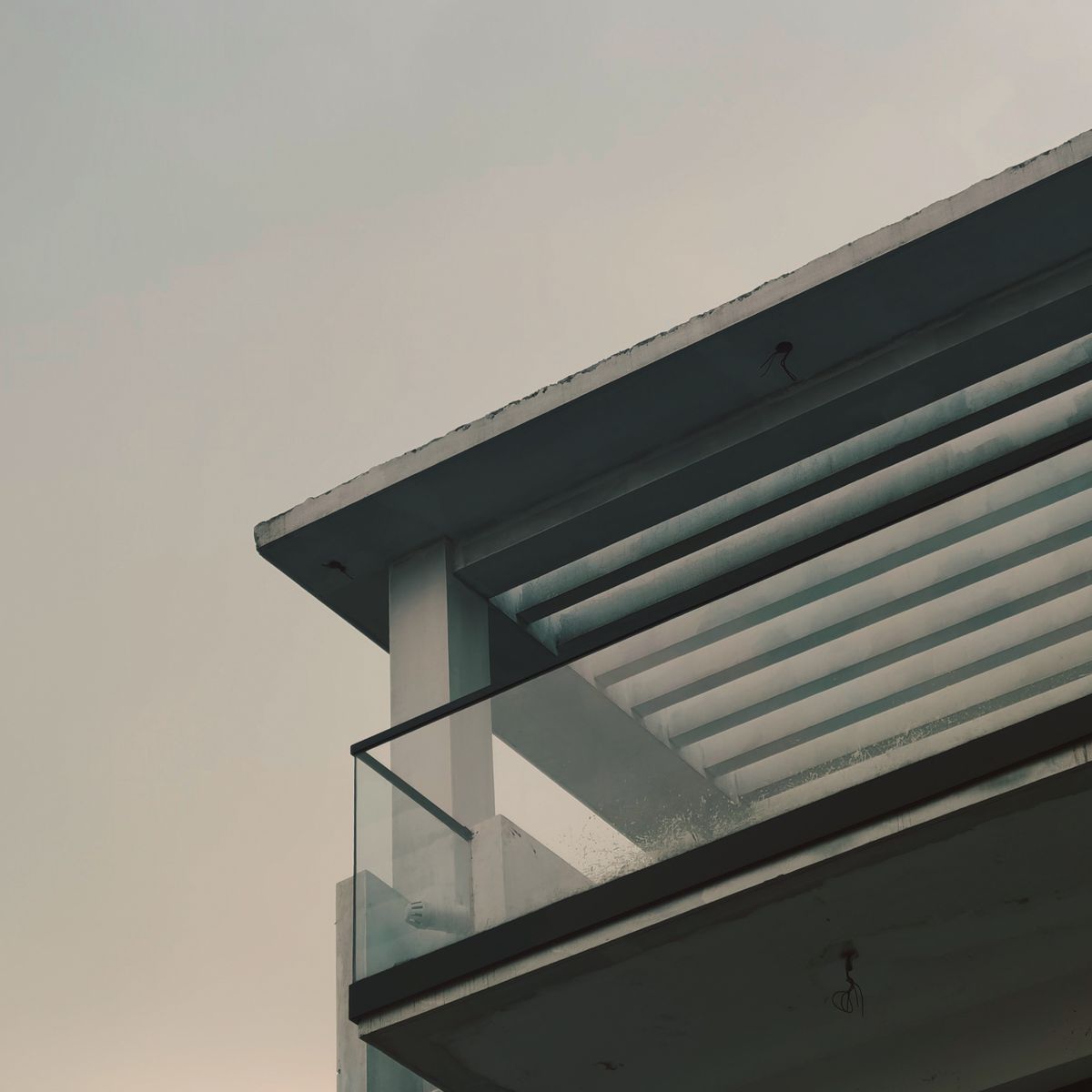 Aluminium-Lamellendach von unten fotografiert an einem Balkon mit Glasbrüstung
