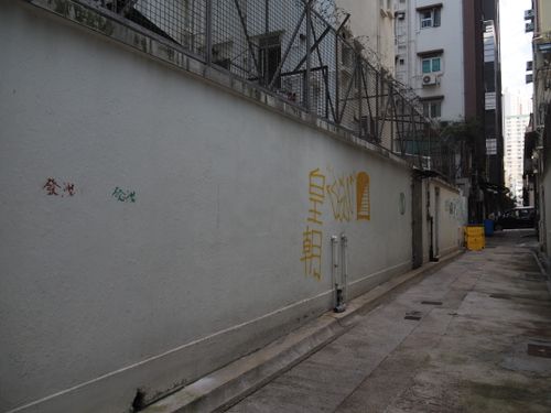 Free Graffiti-laden alleyway in Hong Kong, showcasing urban art and architecture. Stock Photo