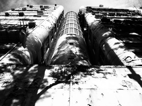 A striking black and white photo of an aged building facade in Hong Kong, showcasing urban decay and architectural detail.