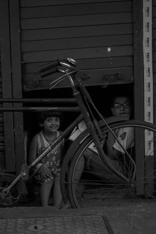 Free Kids Sitting Behind a Bike  Stock Photo