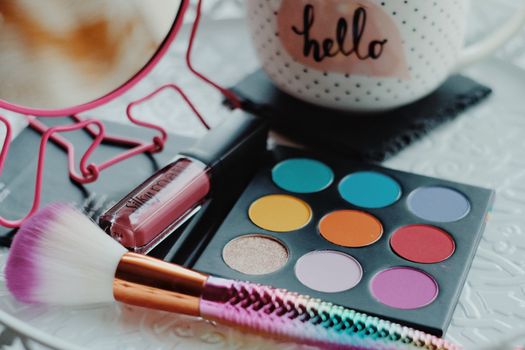 Vibrant eyeshadow palette with lipstick and brush, perfect for beauty enthusiasts.