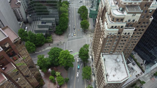 Aerial view of a city intersection surrounded by skyscrapers and greenery, showcasing urban architecture.
