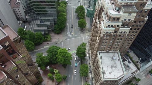 Free Aerial view of a city intersection surrounded by skyscrapers and greenery, showcasing urban architecture. Stock Photo