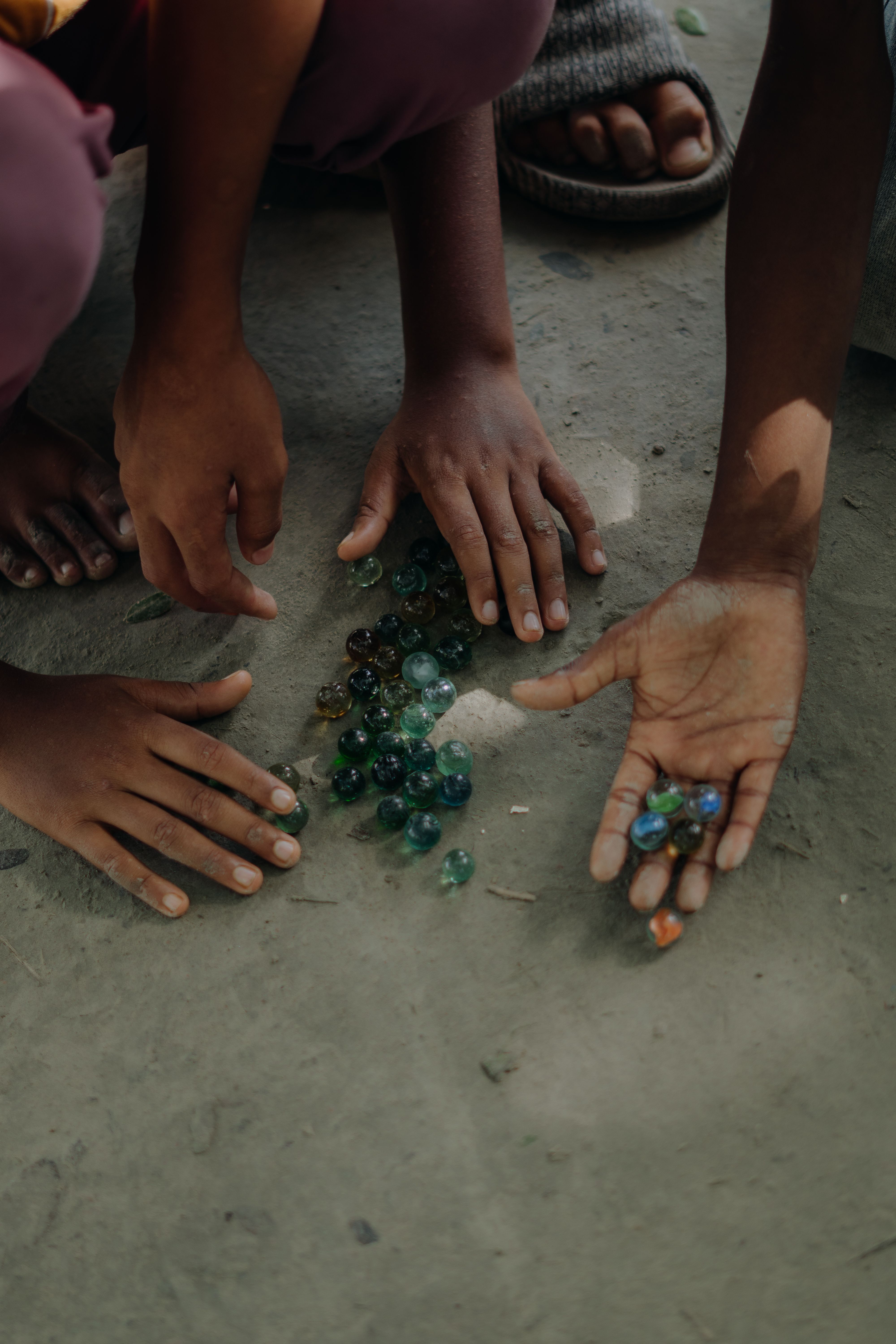 Children playing marbles on sandy ground · Free Stock Photo