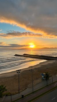Golden sunset over Itapema beach, capturing waves and peaceful ambiance in Brazil.