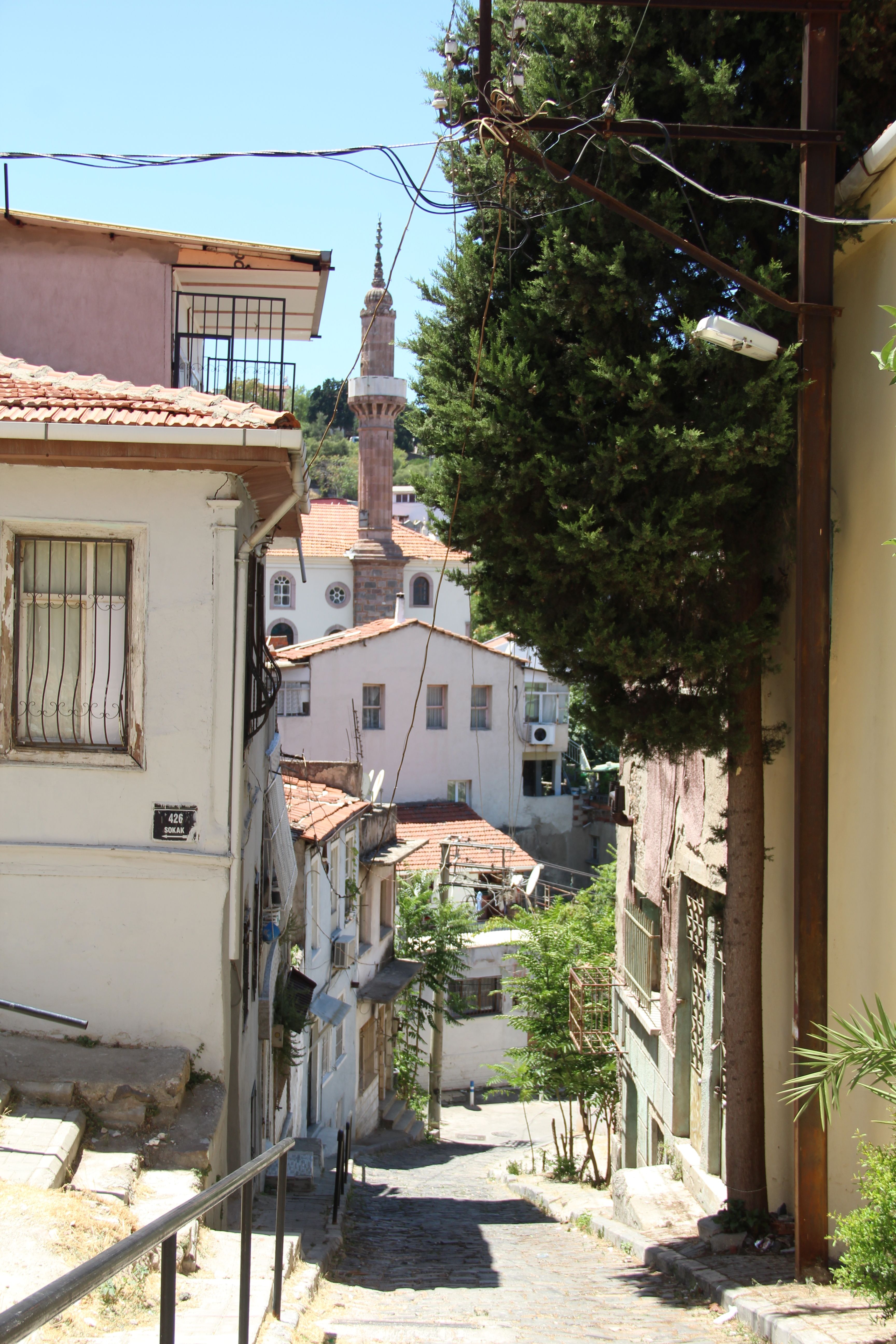 Serene alleyway view leading to a beautiful mosque in Izmir, showcasing traditional architecture.