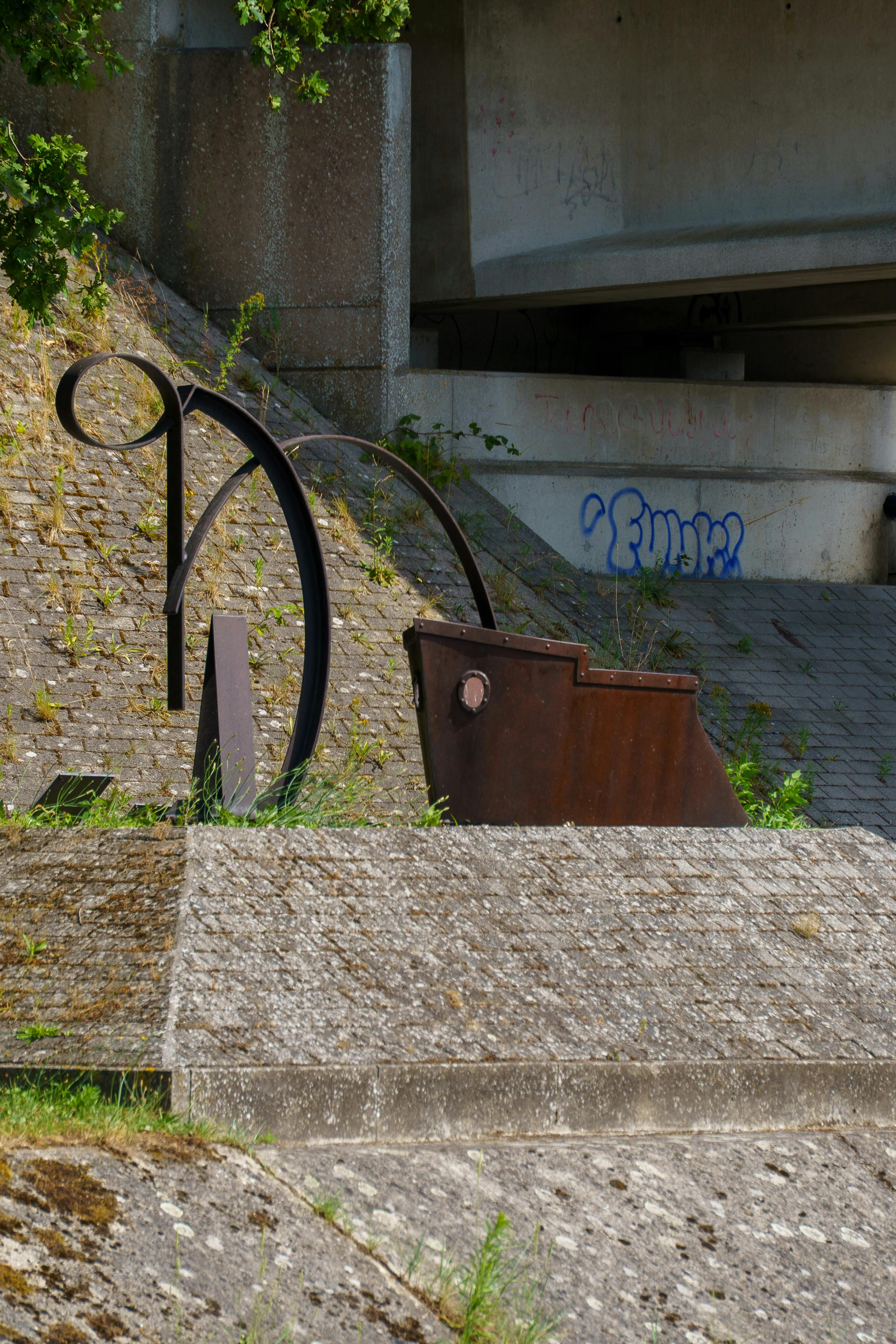 Δωρεάν Ένα αφηρημένο μεταλλικό γλυπτό κάτω από μια γέφυρα στο Ντέσελ του Βελγίου, με ορατά γκράφιτι. Φωτογραφία από στοκ φωτογραφιών