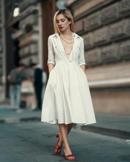 Woman in white midi dress on city street