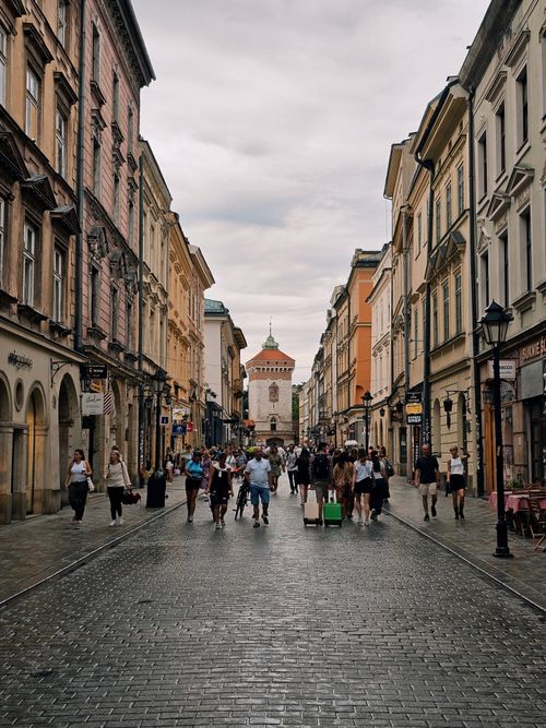 Free A bustling scene on a historic street in Kraków, Poland, with pedestrians and classic architecture. Stock Photo