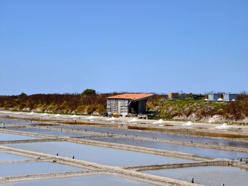 Free Scenic view of salt pans and rustic hut under clear blue skies in Ars-en-Ré, Nouvelle-Aquitaine, France. Stock Photo
