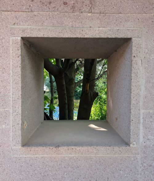 Free A concrete frame provides a unique view of nature with trees and greenery outside. Stock Photo