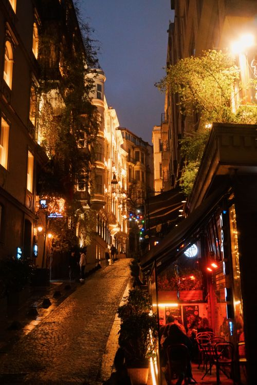 Free Beautifully lit street with historic buildings and cozy cafe at night. Stock Photo