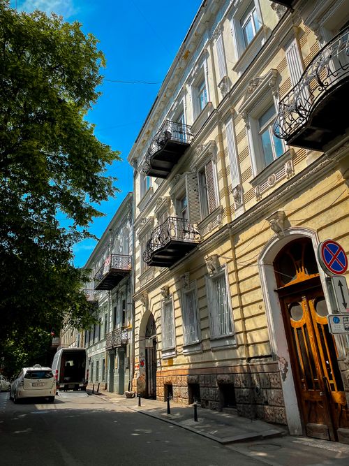 Free Charming daytime scene of a European street lined with historic buildings and lush greenery. Stock Photo