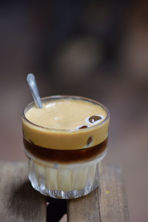 Free A creamy and rich Vietnamese egg coffee in a glass with a spoon, showcasing the layered texture and inviting appearance. Stock Photo