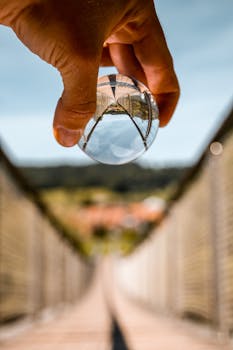 手持水晶球对吊桥进行艺术拍摄，创造出有趣的倒置视角