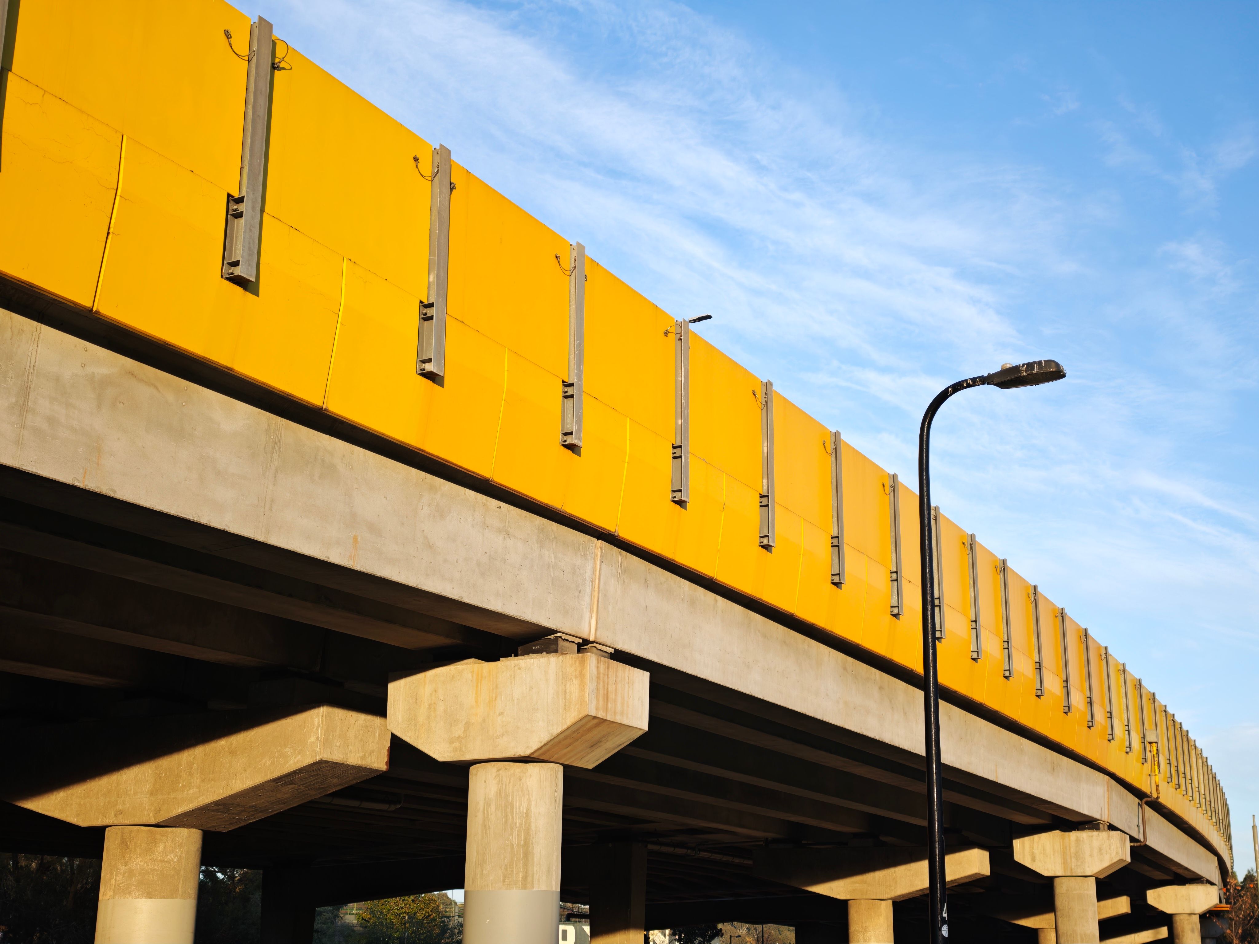 Modern yellow overpass captured under a clear blue sky in Kooyong, Melbourne.
