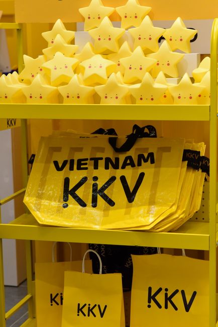 Kê Vàng: Khám phá công dụng, cách dùng và lợi ích tuyệt vời cho sức khỏe từ hạt ngũ cốc. 3 Bright yellow shelf display with star toys and 'Vietnam KKV' bags, perfect retail decor.