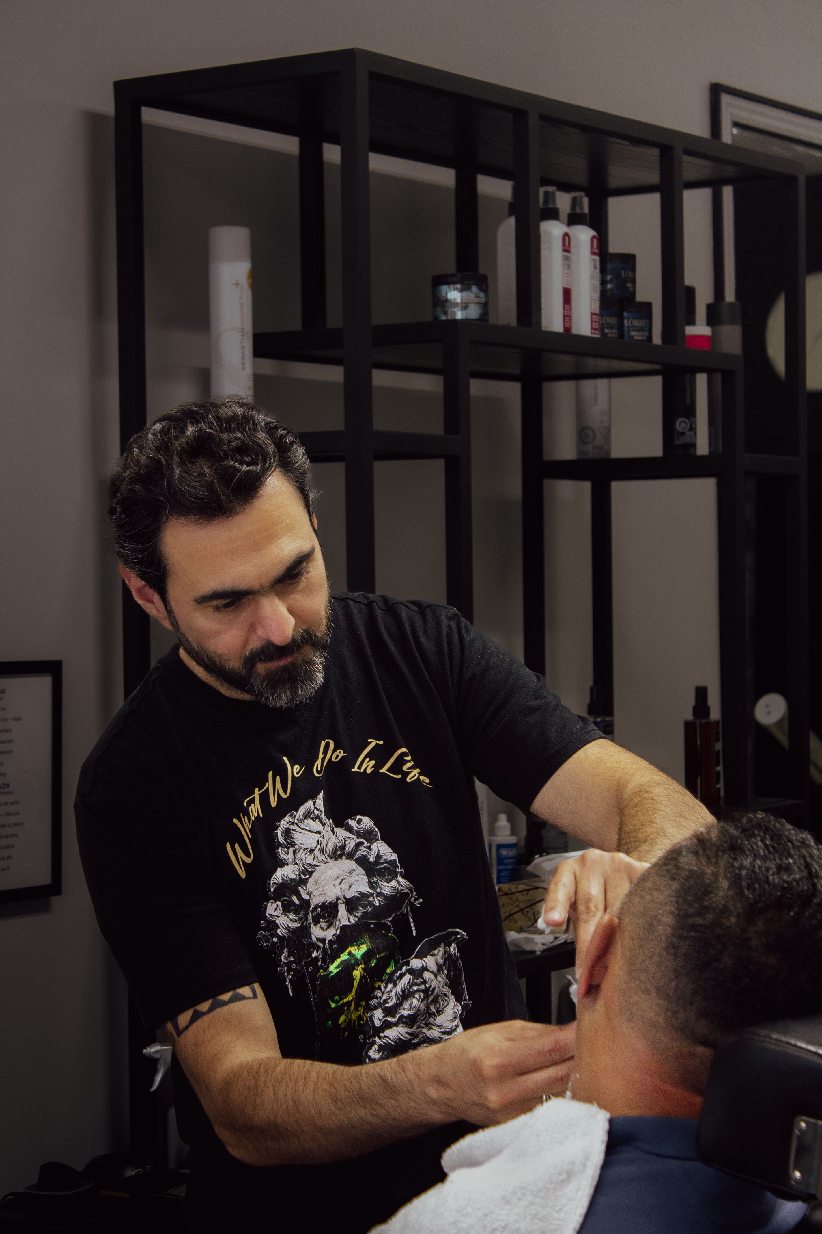 A skilled barber trims a client's hair in a modern salon setting, focusing on detail.